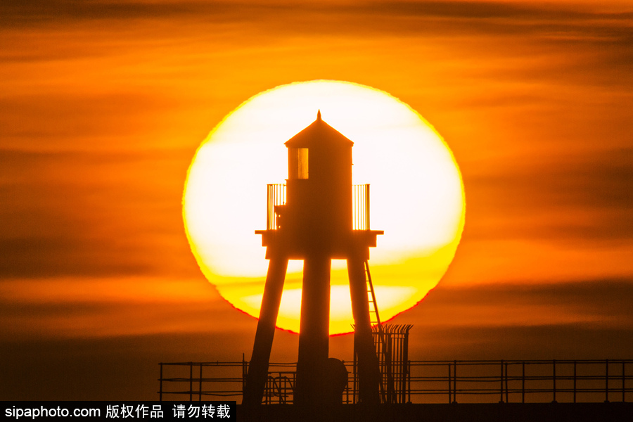 英國惠特比碼頭日出風光 燈塔影影綽綽景色美