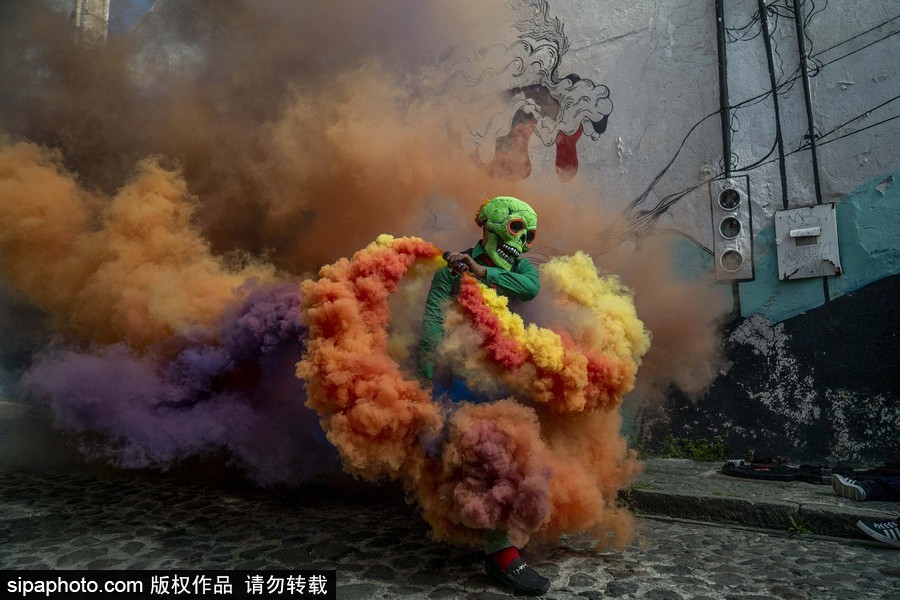 展現(xiàn)色彩魅力！墨西哥街頭“彩色骷髏”花6小時用彩煙“填滿”街道